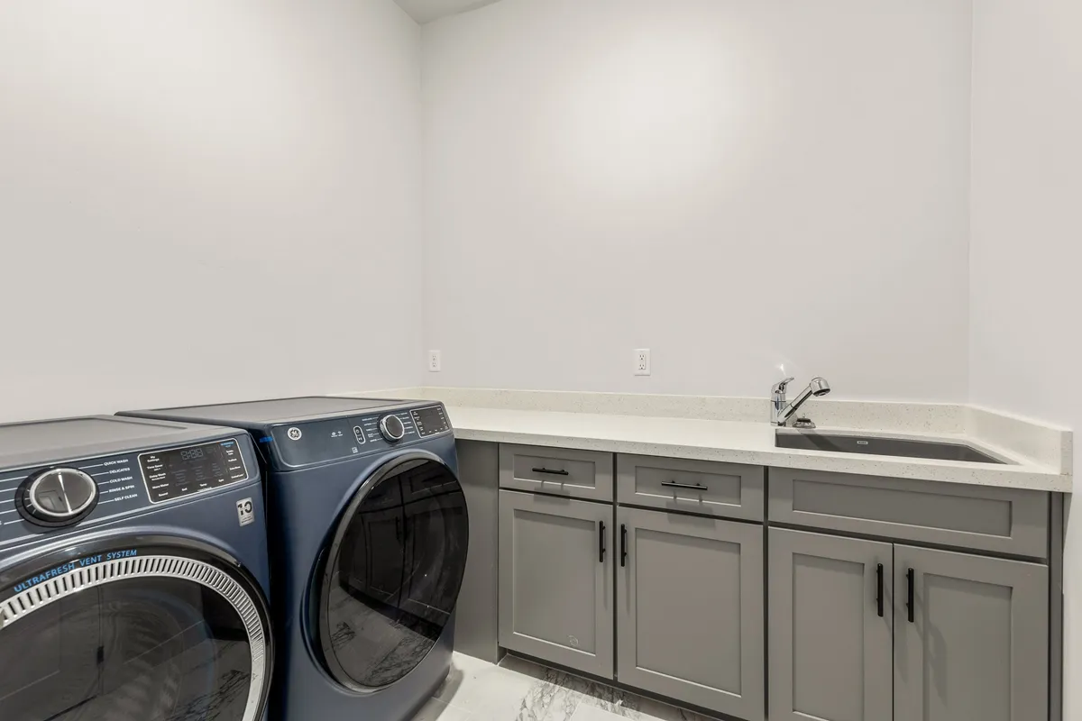 A well-equipped laundry area with washer, dryer, sink, and countertop, designed for efficient and easy use during any stay.