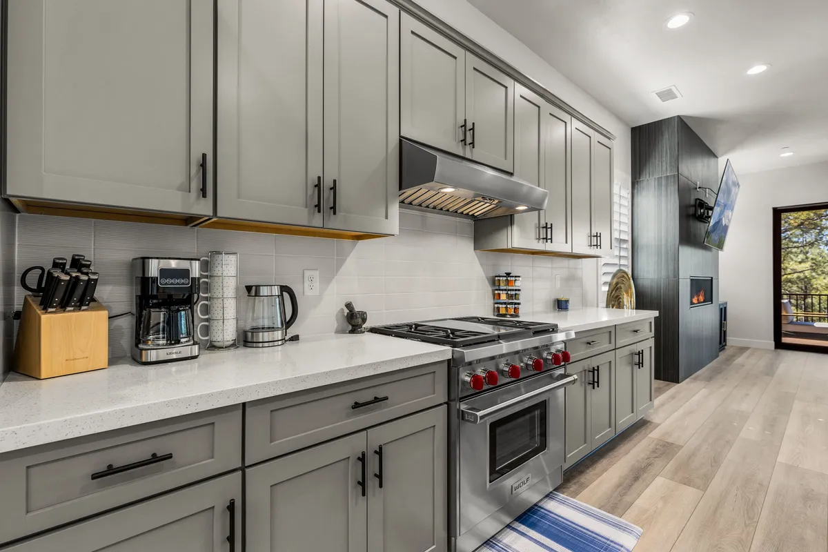A stylish, modern kitchen featuring a large island, stainless steel appliances, and ample space for preparing hearty group meals. Contemporary cabinetry and countertop appliances enhance the inviting, functional vibe.